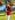 Liquid in red shiny patent leather luxury Apple Watch band on model wearing red blazer and white pants 