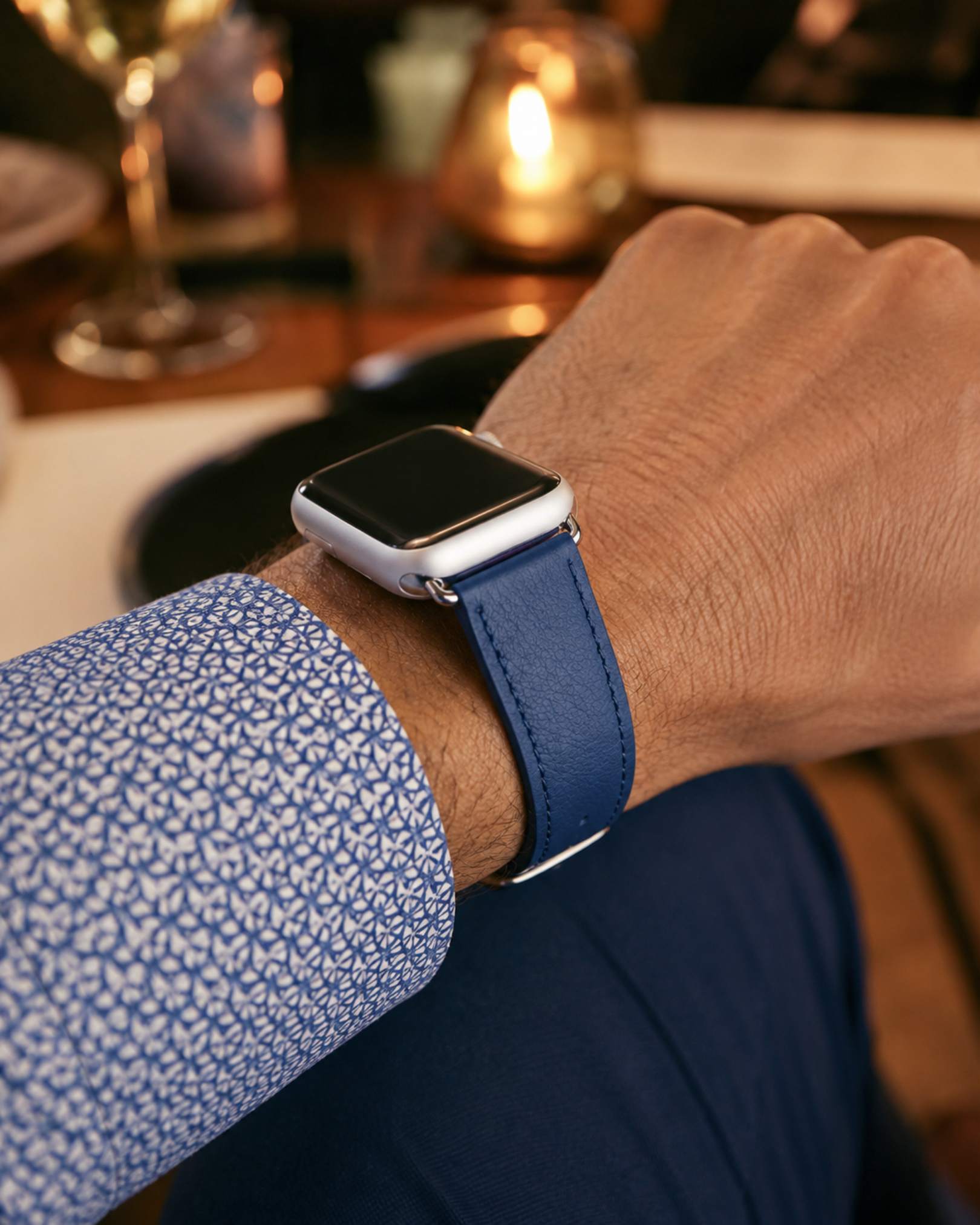 Person wearing a smartwatch with a blue strap in a casual setting
