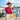 A woman posing outdoors by a swimming pool wearing the Bedarra in Magenta Apple Watch band and a vibrant magenta lace puff-sleeve top, cream pants, a straw hat, and sunglasses.