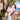 A woman wearing the Liquid in Coral Apple watch band with a white collared dress and a straw bag.