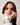 A close-up of a model wearing the Liquid in Teal patent leather Apple Watch band with a white zip-up jacket.