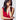 A woman with dark hair wearing the Orleans in Fuchsia Apple Watch band with a low cut red dress.