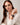 Model wearing the Sorrento in Chocolate luxury Apple Watch band with a cream blouse and brown pants