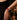 A close-up of a person's hand and wrist wearing the Sorrento in Scarlet Apple Watch band with a black dress with red details. 